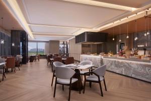 a restaurant with tables and chairs and a bar at Tianjin Marriott Hotel National Convention and Exhibition Center in Tianjin