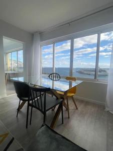 - une salle à manger avec une table, des chaises et des fenêtres dans l'établissement top floor avenida arriaga 802, à Funchal