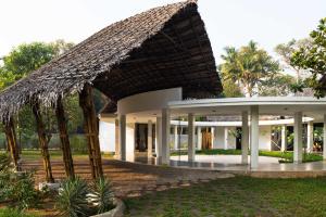 un complejo con un gran edificio con palmeras en Xandari Pearl Beach Resort, en Mararikulam