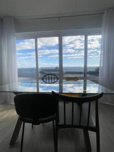 einem Glastisch und einem Stuhl vor einem Fenster in der Unterkunft top floor avenida arriaga 802 in Funchal