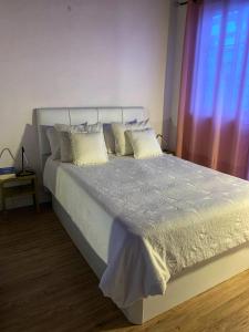 a bedroom with a bed with white sheets and pillows at Casa Mi Mona in Santa Cruz de la Palma