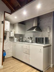 a kitchen with white appliances and a brick wall at Casa Mi Mona in Santa Cruz de la Palma