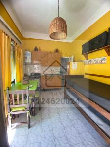 cocina con mesa verde y paredes amarillas en Lacasadelagua en Santa Teresita