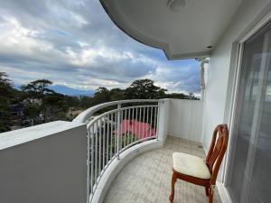 une chaise assise sur un balcon avec vue dans l'établissement 3 Bedroom Condo Unit With View, à Baguio