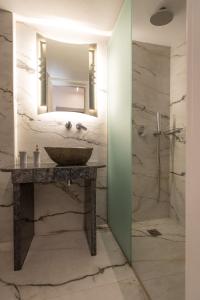 a bathroom with a sink and a shower with a mirror at Irini Studios in Psarou