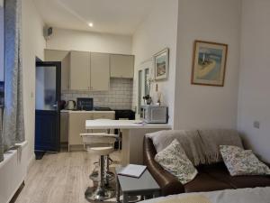 a living room with a couch and a kitchen at Cracatinni Mews in Roundwood