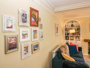 a living room with a blue couch and pictures on the wall at 1 Tower House in Grange Over Sands