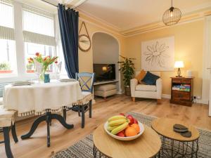 a living room with a table with a bowl of fruit at 1 Tower House in Grange Over Sands