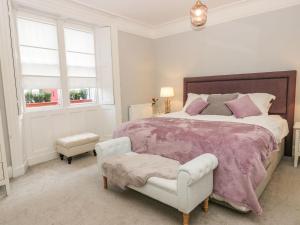 1 dormitorio con 1 cama, 1 silla y ventanas en 1 Tower House, en Grange-over-Sands