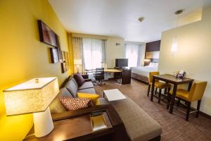 a hotel room with a couch and a bed and a desk at Residence Inn by Marriott Harlingen in Harlingen