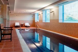 une grande piscine dans un bâtiment dans l'établissement AC Hotel Palacio de Santa Ana by Marriott, à Valladolid
