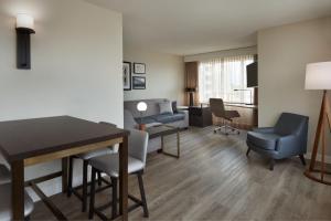 una sala de estar con mesa y sillas en una habitación de hotel en Residence Inn by Marriott London Canada, en London