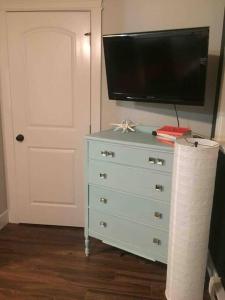 a dresser with a flat screen tv on top of it at Mill Hill Haven in Victoria