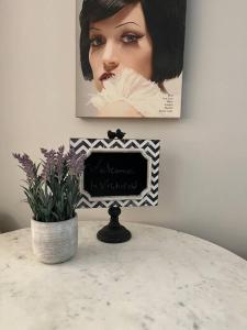 a table with a picture and a vase of flowers at Mill Hill Haven in Victoria