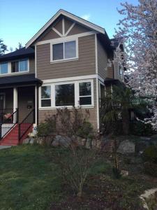 a brown house with a porch and a tree at Mill Hill Haven in Victoria