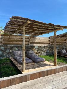 a wooden pergola with pillows on a patio at Chambres d'hôtes et studios de charme - A Mandria in Murato