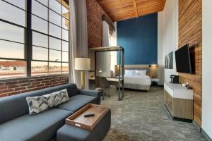 um quarto de hotel com um sofá e uma cama em SpringHill Suites by Marriott Montgomery Downtown em Montgomery