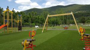a playground with slides and swings on a green field at VUT- La Deliciosa in Sotillo de la Adrada