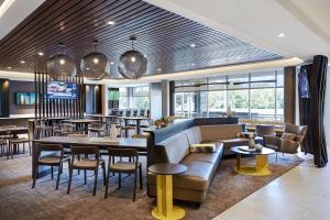 a restaurant with a couch and tables and chairs at SpringHill Suites by Marriott Cleveland Independence in Independence