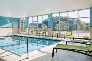 a swimming pool with chairs and tables in a building at SpringHill Suites by Marriott Cleveland Independence in Independence