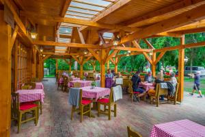 a restaurant with tables and people sitting at them at Lipicai Apartmanházak in Szilvásvárad