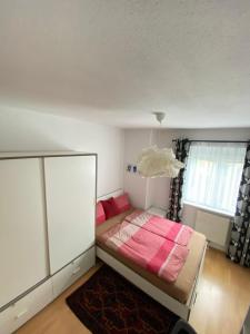 a bedroom with a bed with a pink blanket at cozy apartment close to vienna in Brunn am Gebirge