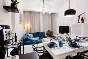 ein Wohnzimmer mit einem Tisch und einem blauen Sofa in der Unterkunft Golden Hour Apartments - Platan Tower in Świnoujście