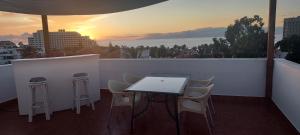 アロナにあるChill out Apartment Tenerifeの夕日を望むバルコニー(テーブル、椅子付)