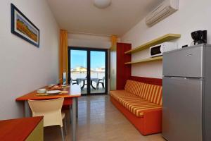 un soggiorno con divano, tavolo e frigorifero di Apartments in Lignano 21632 a Lignano Sabbiadoro