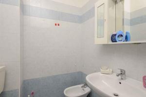 リニャーノ・サッビアドーロにあるApartments in Lignano Sabbiadoro 21788の白いバスルーム(洗面台、トイレ付)