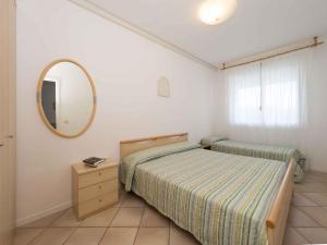 una camera con due letti e uno specchio di Apartments in Lignano Sabbiadoro 21784 a Lignano Sabbiadoro