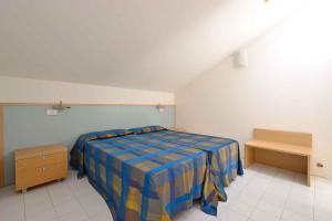 リニャーノ・サッビアドーロにあるApartments in Lignano 21597のベッドルーム1室(青と黄色の毛布付きのベッド1台付)