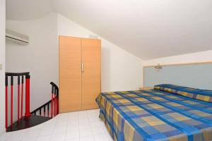 a bedroom with a bed and a cabinet in it at Apartments in Lignano 21597 in Lignano Sabbiadoro