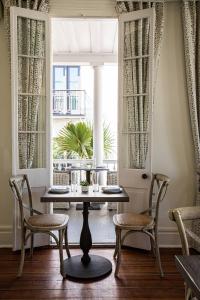 a dining room with a table and chairs and a window at Hotel Bella Grace in Charleston