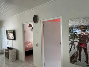 un couloir avec une chambre avec une horloge sur le mur dans l'établissement Casa Augusto, à Willemstad