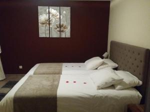een slaapkamer met een bed met twee schilderijen aan de muur bij Les Citronniers d'Azur in Menton