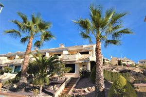 a house with palm trees in front of it at Beautiful house in Campoamor Golf in Villacosta