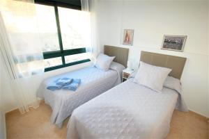 two beds in a room with a window at Beautiful house in Campoamor Golf in Villacosta +35 photos