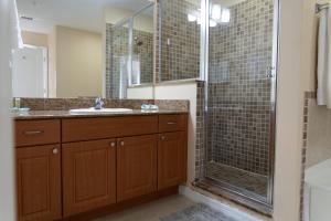 a bathroom with a glass shower and a sink at The Point Hotel & Suites - 705S Luxury - Pool view - Close to Universal in Orlando