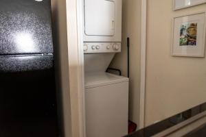 a kitchen with a refrigerator and a washer and dryer at The Point Hotel & Suites - 705S Luxury - Pool view - Close to Universal in Orlando