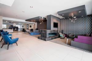 a lobby with blue and purple chairs and a fireplace at Residence Inn by Marriott Winnipeg in Winnipeg