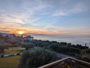 a sunset over the ocean from a balcony of a house at Lichnides Maisonette in Mola Kalyva