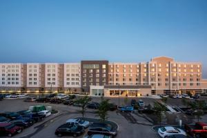 un aparcamiento con coches estacionados frente a un gran edificio en Residence Inn by Marriott Winnipeg, en Winnipeg