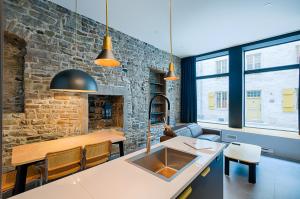 a kitchen with a stone wall and a kitchen sink at Les Lofts Notre-Dame - Par Les Lofts Vieux-Québec in Quebec City