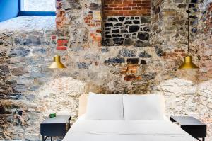 uma cama num quarto com uma parede de tijolos em Les Lofts Notre-Dame - Par Les Lofts Vieux-Québec em Cidade de Quebec