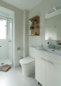 Baño blanco con aseo y lavamanos en Apartamento Hospital Cruces - BEC, en Barakaldo