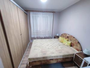 een kleine slaapkamer met een bed en een raam bij Apartman Kristina Ribarska banja in Kruševac
