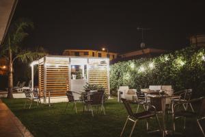 a group of tables and chairs in a yard at night at Verter Home Resort in Ovile la Marina