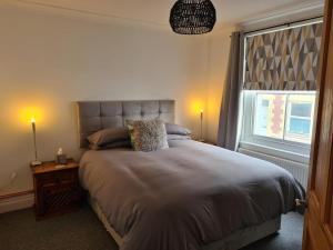 Un dormitorio con una cama grande y una ventana en Beautiful Apartment 3 Mins To The Beach en St. Leonards