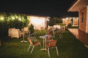 a group of tables and chairs in the grass at night at Verter Home B&B in Ovile la Marina